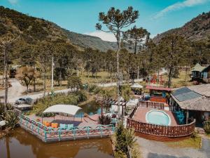 烏魯比西的住宿－Pousada Jardim do Buda Piscina e Hidro，享有河流和游泳池的度假村的空中景致