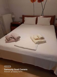 a bed with two towels on top of it at MUSEUM apartment in Volos