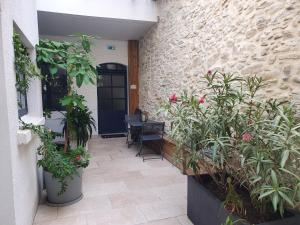 une cour avec des plantes et une porte avec une table dans l'établissement A l ombre des remparts 3, à Carcassonne