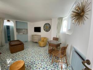 uma sala de estar com mesa e cadeiras em Villa Sain Charming Suite em Anacapri