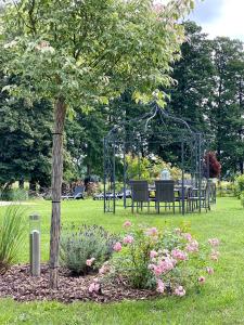 a garden with a table and a gazebo in a park at Ferienapartments Spreewaldwiesen in Vetschau