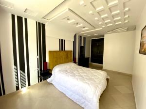 een slaapkamer met een wit bed in een kamer bij Riverside Tétouan in Tetouan