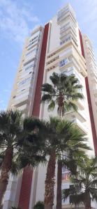a tall building with palm trees in front of it at VISTAMAR 33 in Benidorm
