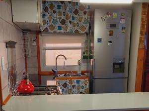 a small kitchen with a sink and a refrigerator at Acogedora casa en Punta Arenas in Punta Arenas