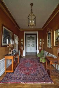 uma sala de estar com um tapete e um lustre em Manoir de la Salle du Roc em Bourré