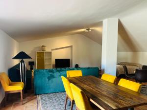 a living room with a wooden table and yellow chairs at Loft en Huelva in Aljaraque