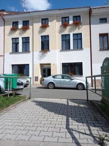 dos coches estacionados frente a un edificio en Apartmán Maršík, en Náchod