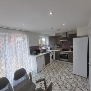 a kitchen with a refrigerator and a counter top at Modern home with Netflix, NowTV & 2private parking in East Tilbury