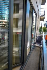 - un balcon avec des portes en verre et une chaise dans un bâtiment dans l'établissement Garden Botanique, à Bruxelles