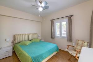a bedroom with a bed with a ceiling fan and a window at Anastasia Home in Triandáros