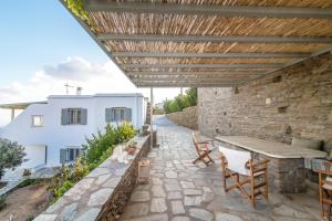 a patio with a table and chairs and a stone wall at Anastasia Home in Triandáros