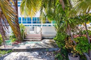 a building with stairs and palm trees in front of it at Girasole Apartments in Miami Beach