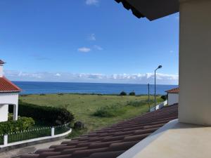 uma vista para o oceano a partir da varanda de uma casa em Mountain and Ocean View em Água de Alto