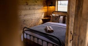 a small bedroom with a bed with a wooden wall at Luxury Safari Lodge surrounded by deer!! 'Fallow' in Crediton