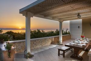 un patio con una mesa con puesta de sol en el fondo en Unique Venetian Style Villa "Leniko" in Crete, en Atsipopoulo