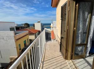 an open door on a balcony with a view of the ocean at Casa Scirocco in Balestrate