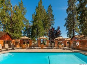 a resort pool with chairs and tables and umbrellas at Cedar Glen Lodge in Tahoe Vista
