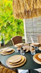 einem grünen Tisch mit Teller und Schüsseln darauf in der Unterkunft Île tropical lodges in Sainte-Anne