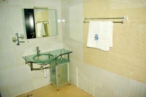La salle de bains est pourvue d'un lavabo, d'un miroir et d'une serviette. dans l'établissement Opal Ville Bamboo Suite, 2-bedroom in a serene area, à Abuja