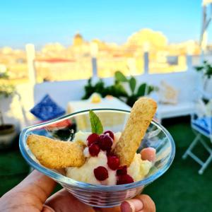 une personne tenant un bol de nourriture avec des fruits et des biscuits dans l'établissement Due Passi Dal Centro, à Marsala