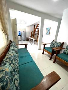 uma sala de estar com um sofá e cadeiras em Casa de Praia com piscina em Boicucanga