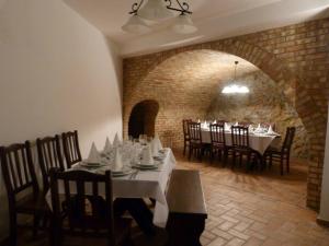 a dining room with tables and chairs and a brick wall at Zempléni Pitvaros Pihenő in Telkibánya
