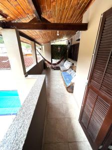 a balcony with a hammock in a house at Casa de Praia com piscina in Boicucanga