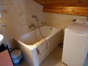 a bathroom with a bath tub next to a refrigerator at il Nido in Tonadico