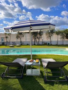 two chairs and an umbrella next to a pool at Villa Miami Vieste in Vieste