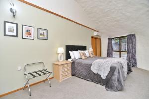 1 dormitorio con 1 cama, 1 silla y 1 ventana en Koepel House - Christchurch Holiday Homes, en Christchurch