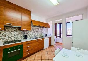 ポルティマンにあるFLH Portimão Apartment with Viewのキッチン(木製キャビネット、白いカウンタートップ付)