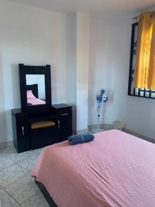 sypialnia z łóżkiem, lustrem i wentylatorem w obiekcie Flavio Reyes w mieście Manta