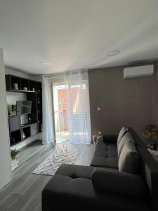 uma sala de estar com um sofá e uma grande janela em GOLDEN - self CHECK IN em Osijek