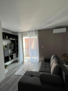 a living room with a couch and a large window at GOLDEN - self CHECK IN in Osijek