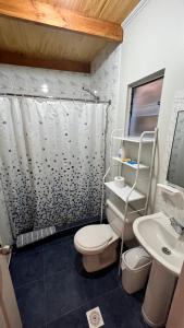 y baño con ducha, aseo y lavamanos. en Hostal Ckamai, en San Pedro de Atacama