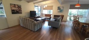 a living room with a couch and chairs and a tv at Beauna Vista Rye Holiday Home in Rye