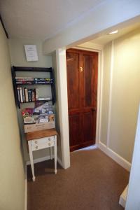 a hallway with a door and a shelf with books at Fitzwarine House Whittington in Whittington