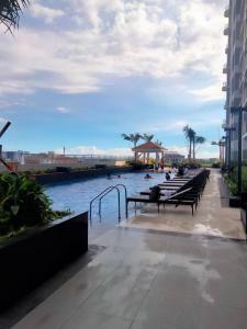 マニラにあるStayInMyCondo - 8th Condo in Pasay near NAIA Airport, MOA Pasayの水の横のベンチの列