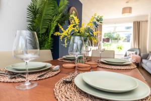 uma mesa de madeira com pratos e copos de vinho em 3 Bedrooms house ideal for long Stays! em Southampton
