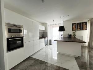 a kitchen with white cabinets and a black counter top at Disney/Paris -Jacuzzi -3 Bedroom in Bussy-Saint-Georges