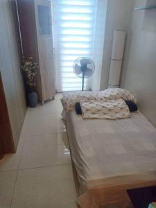 a bedroom with two beds and a lamp and a window at StayInMyCondo - 8th Condo in Pasay near NAIA Airport, MOA Pasay in Manila