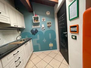 eine Küche mit einem Waschbecken und einer schwarzen Tür in der Unterkunft Mansardine Metropolitane in Brescia