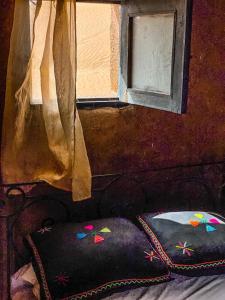 姆哈米德的住宿－Erg Chegaga Camp & Activites，一张带窗户和枕头的床的画