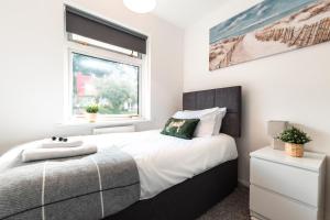 um quarto com uma cama e uma janela em 3 Bedrooms house ideal for long Stays! em Southampton