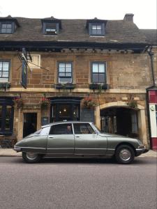 a green car parked in front of a building at The Crown in Uppingham