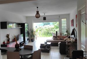 uma sala de estar com um sofá e uma mesa em Chambre privée près des plus belles plages du Nord em La Trinité