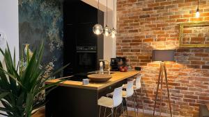 a kitchen with a counter and a brick wall at Designwohnung Schaufenster sehr zentral gelegen in Hannover