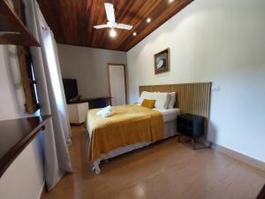 een slaapkamer met een bed en een plafondventilator bij Pousada Schueng in Trindade