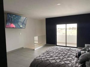 - une chambre avec un lit et une télévision à écran plat dans l'établissement Hermoso apartamento con alberca, 