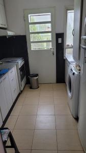 a kitchen with a washing machine and a window at Hospedaje Janet in Trelew